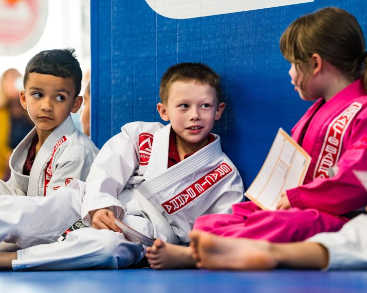 Young Gracie Barra students sitting together on the mats